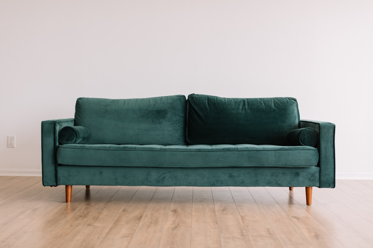 Green velvet sofa in a modern lounge
